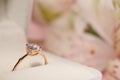 Beautiful engagement ring with gemstone in box on blurred background, closeup. Space for text Royalty Free Stock Photo