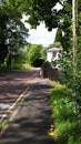 A beautiful English countryside lane with white house and stone wall Royalty Free Stock Photo