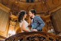 Beautiful enloved and playful just married couple embracing on amazing old stairs with the background of royal wooden Royalty Free Stock Photo