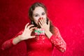 Beautiful enthusiastic girl with a small gift in a red dress Royalty Free Stock Photo