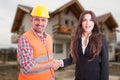 Beautiful estate agent handshake with construction male