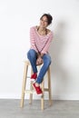 Beautiful ethnic girl sitting on a stool enjoying free time Royalty Free Stock Photo