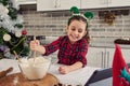 Beautiful European child, adorable girl with elf hoop on her head , little chef blogger mixing ingredients in a glass bowl with Royalty Free Stock Photo