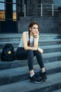 Beautiful European student with a backpack sitting on the steps near the University, close-up. A young pretty student in jeans