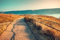 Dirt road with a wooden fence along the river Royalty Free Stock Photo