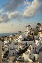 Beautiful evening light scene of Oia white building townscape and windmill along island mountain, Aegean sea, abstract cloud Royalty Free Stock Photo