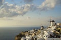 Beautiful evening light scene of Oia white building townscape and windmill along island mountain, vast Aegean sea, abstract cloud Royalty Free Stock Photo