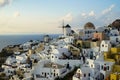 Beautiful evening light scene of Oia white building townscape and windmill along island mountain, vast ocean, soft cloud Royalty Free Stock Photo