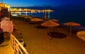 Beautiful evening with night shore with a beach and umbrellas and highlighted with bright colorsin Hersonissos bay Crete Royalty Free Stock Photo
