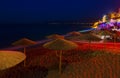 Beautiful evening with night shore with a beach and umbrellas and highlighted with bright colorsin Hersonissos bay Crete Royalty Free Stock Photo