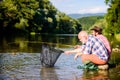 Beautiful evening riverside. Men at riverside catching fish. Friends spend nice time at riverside. Experienced fisherman Royalty Free Stock Photo