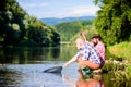 Beautiful evening riverside. Men at riverside catching fish. Teaching fishing. Sharing his secrets. Experienced Royalty Free Stock Photo