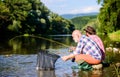 Beautiful evening riverside. Men riverside catching fish. Teaching fishing. Sharing his secrets. Transferring knowledge Royalty Free Stock Photo