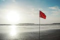 Beautiful evening sky at an isolated beach with red warning flag Royalty Free Stock Photo