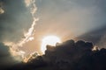 Beautiful evening skyscape. Sun`s rays shine through hole in black clouds before rain, natural background Royalty Free Stock Photo