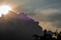 Beautiful evening skyscape. Sun`s rays shine through hole in black clouds before rain, natural background Royalty Free Stock Photo