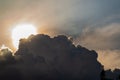 Beautiful evening skyscape. Sun`s rays shine through hole in black clouds before rain, natural background Royalty Free Stock Photo