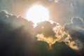 Beautiful evening skyscape. Sun`s rays shine through hole in black clouds before rain, natural background Royalty Free Stock Photo