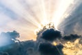 Beautiful evening skyscape. Sun`s rays shine through hole in black clouds after rain Royalty Free Stock Photo