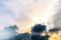 Beautiful evening skyscape. Sun`s rays shine through hole in black clouds after rain