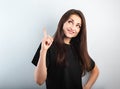 Beautiful excited casual woman in black t-shirt pointing the finger up with toothy smiling on empty copy space. Closeup Royalty Free Stock Photo