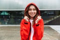 Beautiful excited emotional young happy pretty woman in raincoat posing outdoors