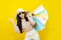 Beautiful excited happy young shopaholic asian woman wearing sungalsses and floppy hat posing isolated over yellow background Royalty Free Stock Photo