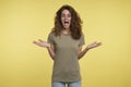 Beautiful excited and joyful young brunette female in eyeglasses and t-shirt gestures with hands and wide opened mouth