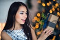 Beautiful excited smiling young woman with present gift feeling happy near christmas tree. Close-up portrait Royalty Free Stock Photo