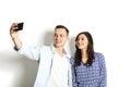 Beautiful excited young straight couple making funny faces, laughing, smiling & taking selfie, having fun w/ mobile cell phone cam Royalty Free Stock Photo