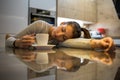 Beautiful exhausted young woman fell asleep while drinking coffee
