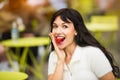 Beautiful exited woman eating strawberry lunch out of office on city street on public place.