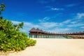 Beautiful exotic beach and amazing wooden bungalow on turquoise water Royalty Free Stock Photo