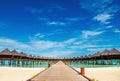 Beautiful exotic beach and wooden bridge to amazing exotic bungalows on turquoise water Royalty Free Stock Photo