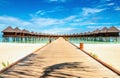 Beautiful exotic beach and wooden bridge to amazing exotic bungalows on turquoise water Royalty Free Stock Photo