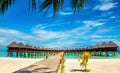 Beautiful exotic beach and wooden bridge to amazing exotic bungalows on turquoise water Royalty Free Stock Photo