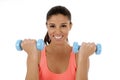Beautiful and exotic hispanic woman holding hand weights training in fitness concept