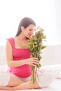 Beautiful expectant mother with cute pink flowers Royalty Free Stock Photo