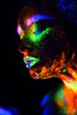 Beautiful extraterrestrial model woman in neon light. It is portrait of beautiful model with fluorescent make-up, Art Royalty Free Stock Photo