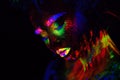 Beautiful extraterrestrial model woman in neon light. It is portrait of beautiful model with fluorescent make-up, Art Royalty Free Stock Photo
