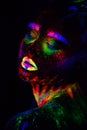 Beautiful extraterrestrial model woman in neon light. It is portrait of beautiful model with fluorescent make-up, Art Royalty Free Stock Photo