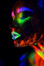 Beautiful extraterrestrial model woman in neon light. It is portrait of beautiful model with fluorescent make-up, Art Royalty Free Stock Photo