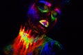 Beautiful extraterrestrial model woman in neon light. It is portrait of beautiful model with fluorescent make-up, Art Royalty Free Stock Photo