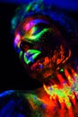 Beautiful extraterrestrial model woman in neon light. It is portrait of beautiful model with fluorescent make-up, Art Royalty Free Stock Photo