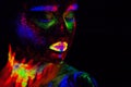 Beautiful extraterrestrial model woman in neon light. It is portrait of beautiful model with fluorescent make-up, Art Royalty Free Stock Photo