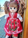 Beautiful fabric doll in red traditional dress with flowers Royalty Free Stock Photo