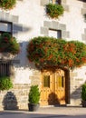 Beautiful facade of old house with flowers. Traditional facade of ancient building in sunlight. Street in mediterranean village.
