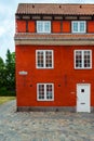 Beautiful facade of an old red brick building with white windows. Royalty Free Stock Photo