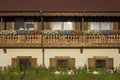 Beautiful facade of a rural village two-story house with a balcony and fresh flowers and a bright fresh lawn Royalty Free Stock Photo