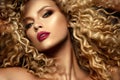 Beautiful face of a fashion model with blue eyes.Curly hair. Red lips.